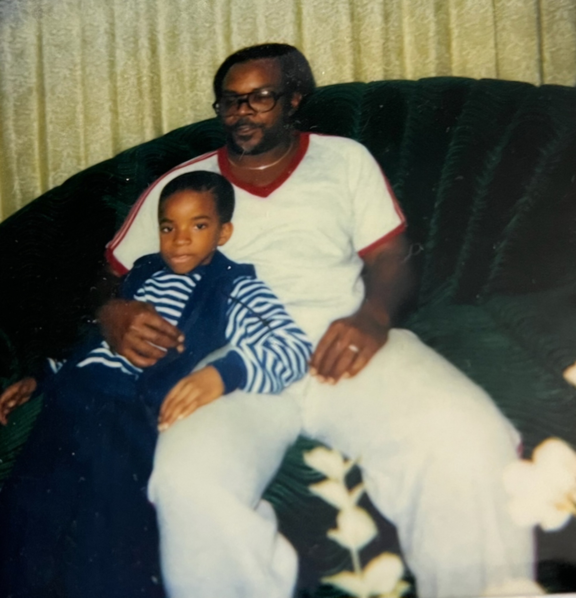 A childhood photograph of Tiko sitting on his dad Robert Blane’s lap
